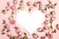 Blank heart-card with small dry roses on pink background. Place Royalty Free Stock Photo