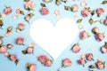 Blank heart-card with small pink roses on blue background. Place Royalty Free Stock Photo