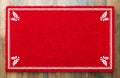 Blank Holiday Red Welcome Mat With Holly Corners On Wood Floor Royalty Free Stock Photo