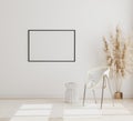 Blank horizontal picture frame mock up on white wall in modern interior background with chair and pampas grass on wooden floor, Royalty Free Stock Photo