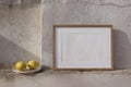 Blank horizontal wooden picture frame mockup against white old textured shabby white wall. Fresh yellow lemons fruit Royalty Free Stock Photo