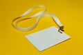 Blank identification card with white neckband isolated on yellow background