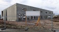 Blank information board in the construction site, where they are building a new industrial building made of large prefab concrete