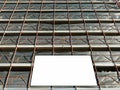 Blank information board hanging on the scaffoldings around the facade under construction. Bottom view