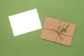 Blank invitation or greeting card mockup and brown tied envelope with a twig. Top view, flat lay. Royalty Free Stock Photo