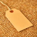 Blank Kraft Paper Tag on Rustic Burlap Texture Empty Label Concept Royalty Free Stock Photo
