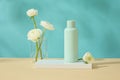 Blank label bottle standing on rectangle podium. A beaker featured few white flowers