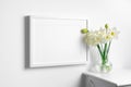 Blank landscape picture frame mockup in white interior with spring flowers Royalty Free Stock Photo