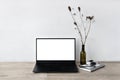 Blank laptop screen mockup, minimalist home office workspace, vase with flowers, stationery and opened laptop on neutral Royalty Free Stock Photo