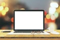 Blank laptop screen on wooden table with eyeglasses and cup of c