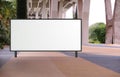 Blank large billboard advertising banner mockup in a large open space with plants under a modern bridge. Large horizontal digital