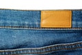 Blank leather label on blue jeans on white Royalty Free Stock Photo