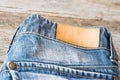 Blank leather label blue jeans on wooden background. Royalty Free Stock Photo