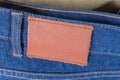 Blank leather label sewed on waistband of the blue jeans