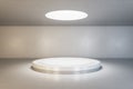 Blank light round illuminated from top podium in empty loft style hall with concrete floor and walls. Mockup