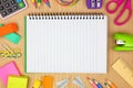 Blank, lined notebook with school supplies frame against a wood desk background with copy space. Royalty Free Stock Photo