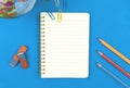 Blank lined notebook mockup with school stationery, pencils on blue background, flat lay composition top view photo Royalty Free Stock Photo