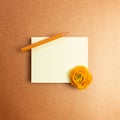 Blank memo pad with dry flower and colored pencil on orange background Royalty Free Stock Photo