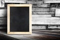 Blank menu blackboard leaning at plank wood wall and diagonal wood floor,Mock up for adding your design Royalty Free Stock Photo