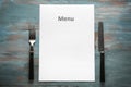 Blank menu with cutlery on wooden table