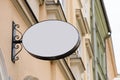 Blank metal oval store signboard on street hanging mounted on the wall