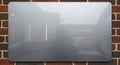 Blank metallic sign mounted on a rustic brick wall with reflections Royalty Free Stock Photo