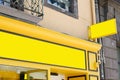 Blank mock up of logo sign in front of yellow facade shop wall