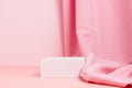 Blank mockup podium with textile fabric drape on pink background