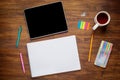 Blank modern digital tablet with papers and pen on a wooden desk. Top view Royalty Free Stock Photo