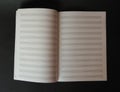 Blank music sheet book for writing notes isolated on black background