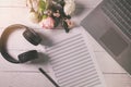 blank musical notes sheet on the wooden table with laptop and headphones Royalty Free Stock Photo