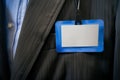 blank nametag with a blue border on a dark suit jacket