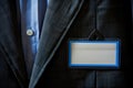 blank nametag with a blue border on a dark suit jacket