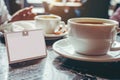 blank nametag beside a coffee cup with person in cafe