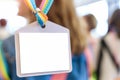 blank nametag on a colorful lanyard, person in the background