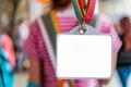 blank nametag on a colorful lanyard, person in the background