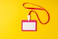 Blank nametag on a string on yellow background copy space