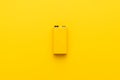 Minimalist photo of blank nine-volt battery on the yellow background