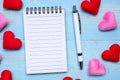 Blank note book and pen with red and pink heart shape decoration on blue wooden table background. Love, Wedding, Romantic and Royalty Free Stock Photo