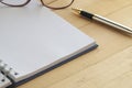 Blank note book with silver pen and glasses. Royalty Free Stock Photo