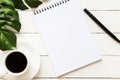 Blank note pad, pen and a cup of coffee on white wooden table Royalty Free Stock Photo