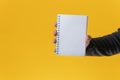 Blank note pad towards the camera over yellow background Royalty Free Stock Photo