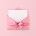 Blank note paper in pink envelope with pink ribbon bow on pink pastel color background Royalty Free Stock Photo