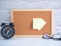 The blank note pinned on a cork board with clock and glasses Royalty Free Stock Photo