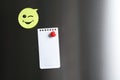 Blank note and sticker with funny face on refrigerator door. Royalty Free Stock Photo