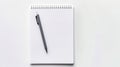 A blank notebook with a black pen on a white surface. This image shows a white spiral notebook with horizontal lines and Royalty Free Stock Photo