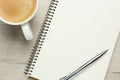 Blank notebook, cup of coffee and pen on white wooden table, flat lay Royalty Free Stock Photo