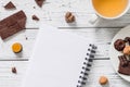 Blank notebook with cup of tea and raw vegan chocolate candies Royalty Free Stock Photo