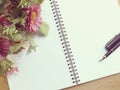 Blank notebook diary with pink flower on wooden background Royalty Free Stock Photo