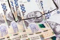 Blank notebook, glasses and ukrainian money on a wooden background. Banknote of 500 hryvnia. Hryvnia UAH.. Close-up